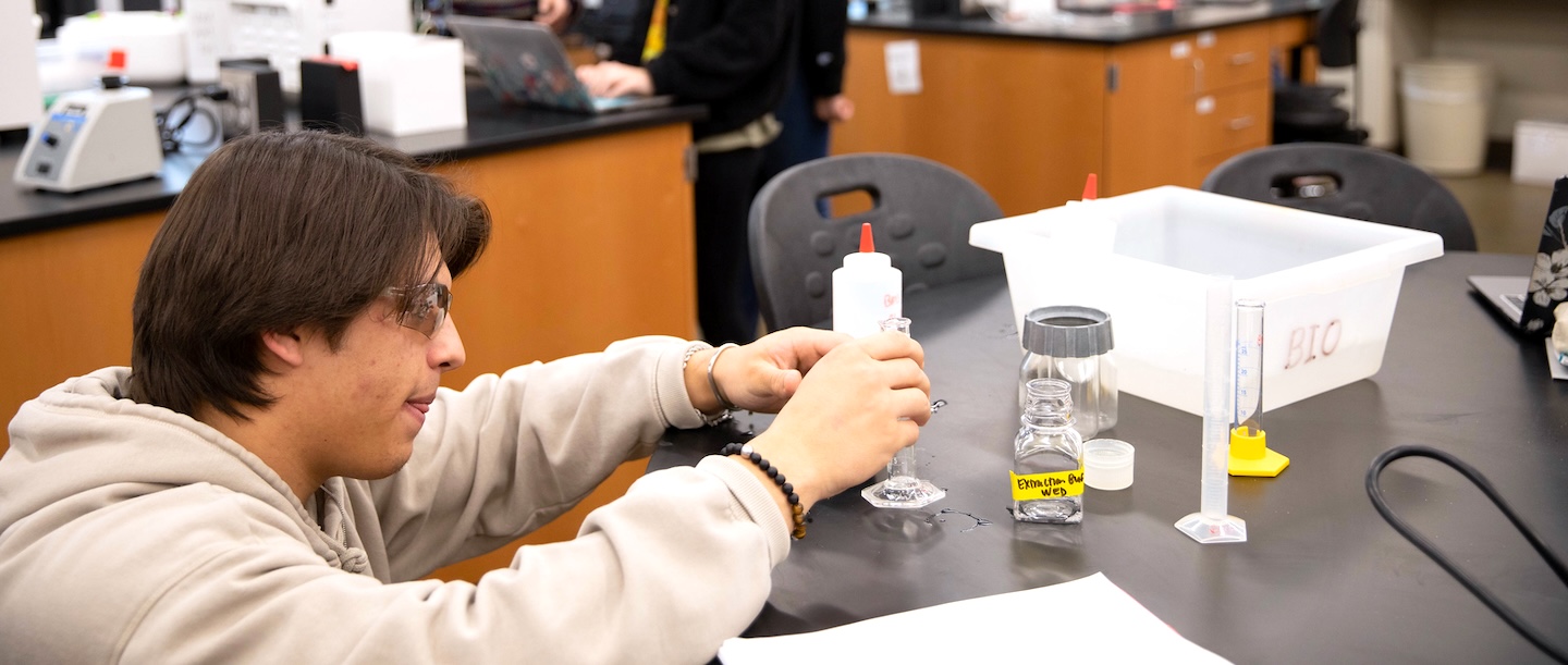 A student in the sciences measures a liquid. 