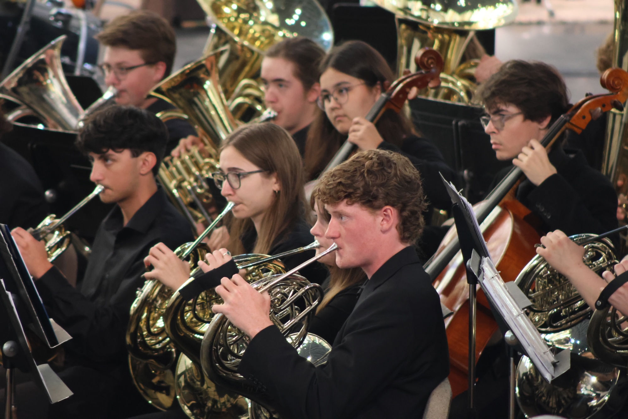 Students in the Gustavus Wind Orchestra performing on brass and string instruments in Christ Chapel.