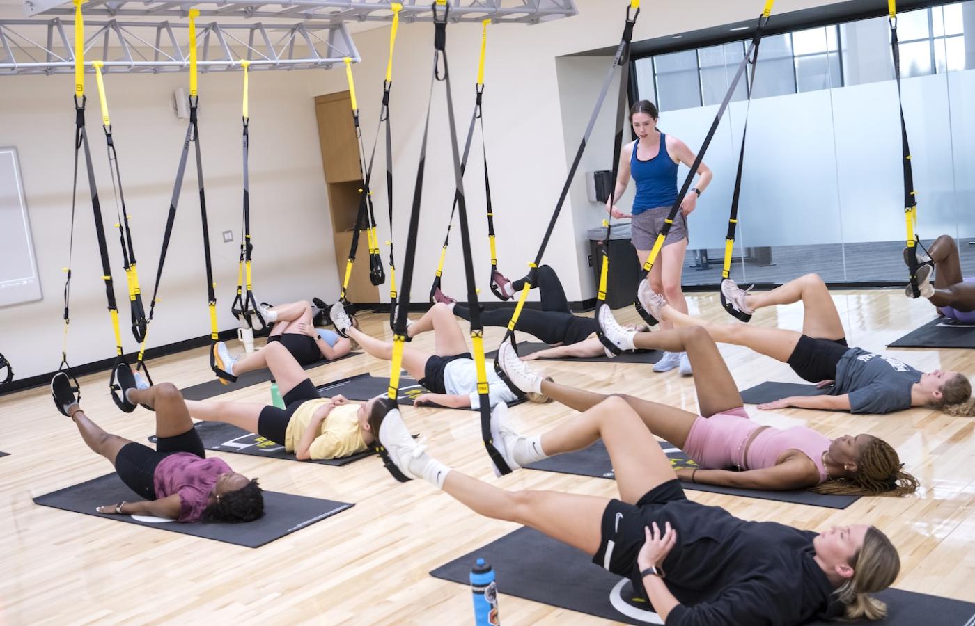 A woman leads a TRX class