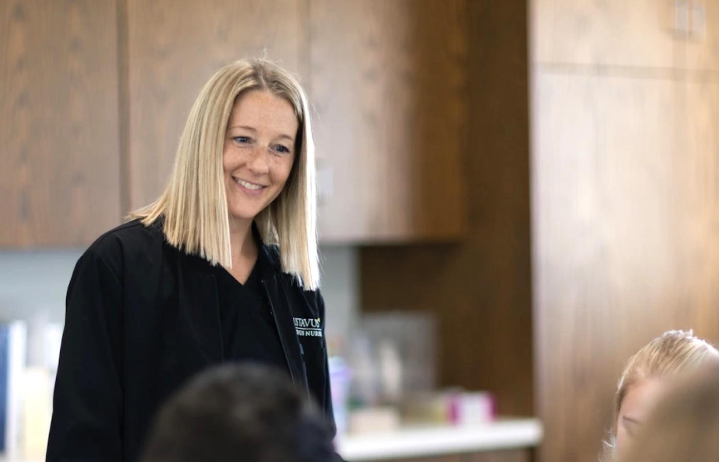 A young public health student smiles at others. 