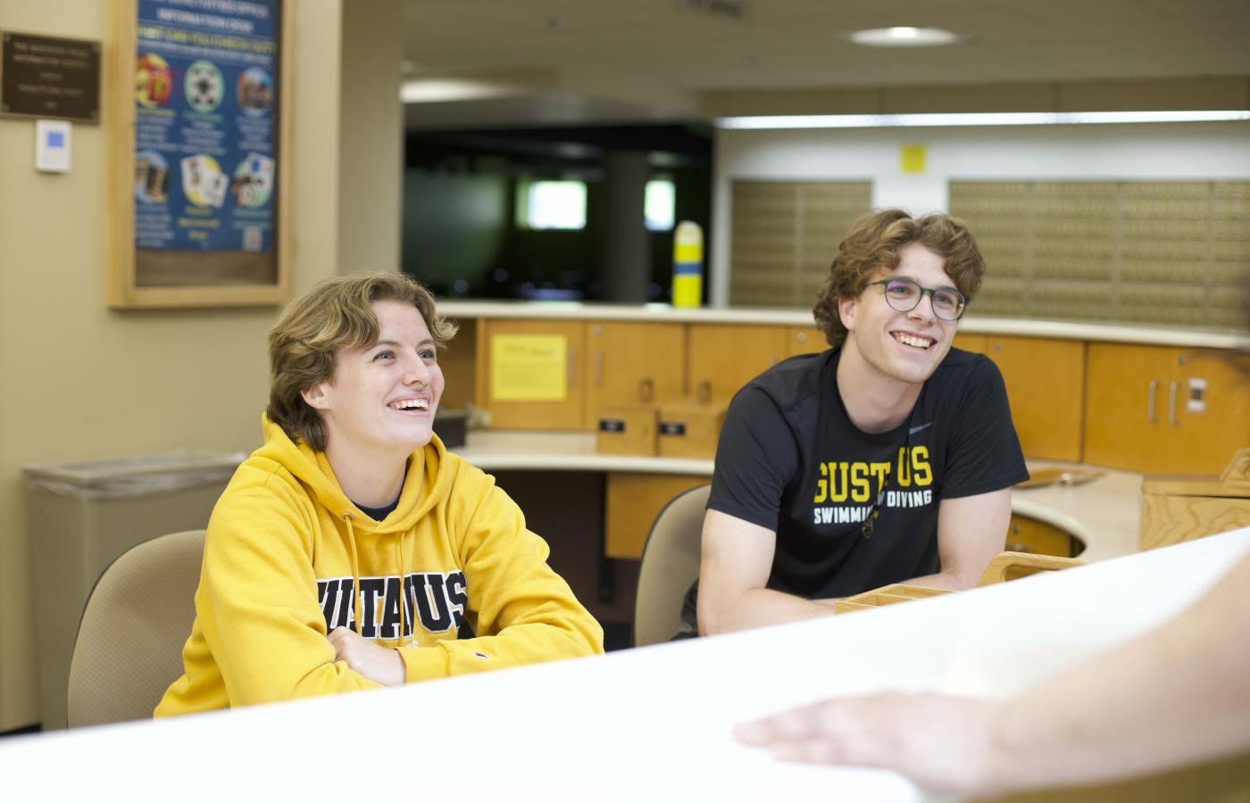 Two college students look intently as they answer someone's question. 