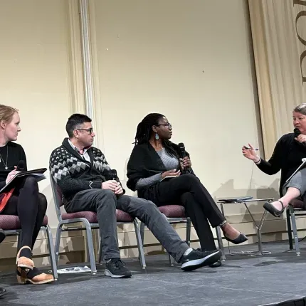 Faculty members engage in a panel discussion on stage, with one honored for outstanding teaching with the Swenson-Bunn Award.