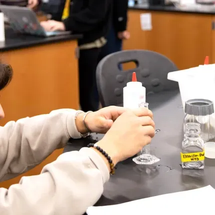 A student in the sciences measures a liquid. 