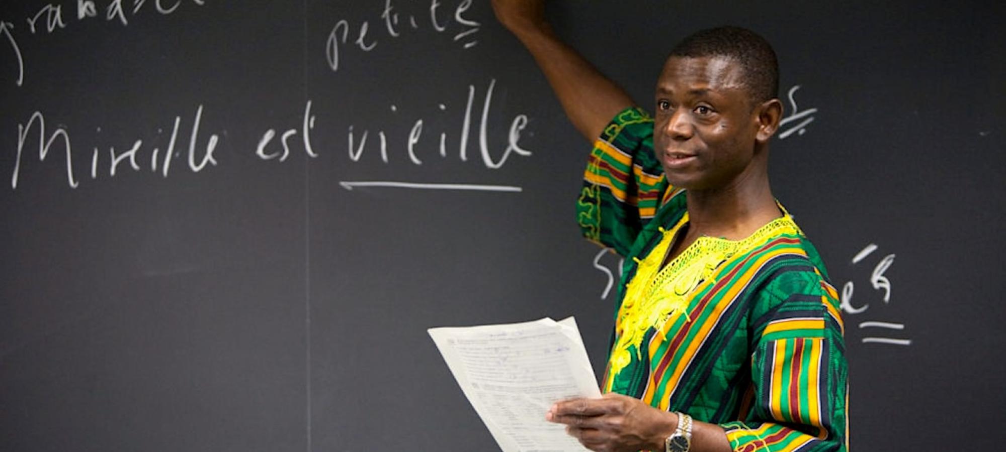 A professor of African Diaspora Studies points to French on a chalkboard.