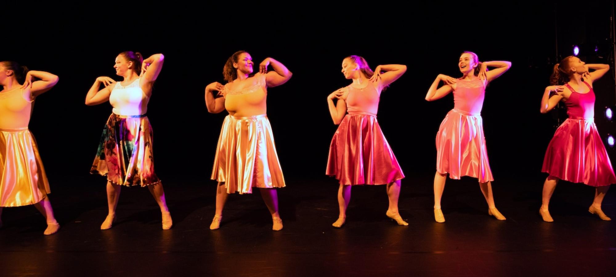 A line of women students dancing. 