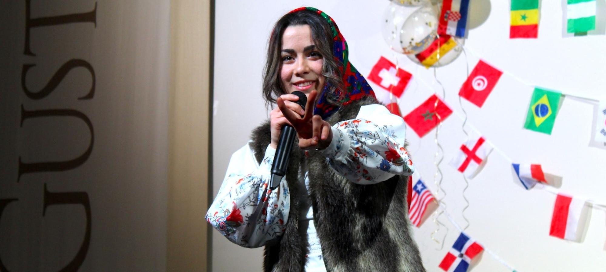 A Gustavus Adolphus College student in traditional Eastern European dress gives a peace sign.  