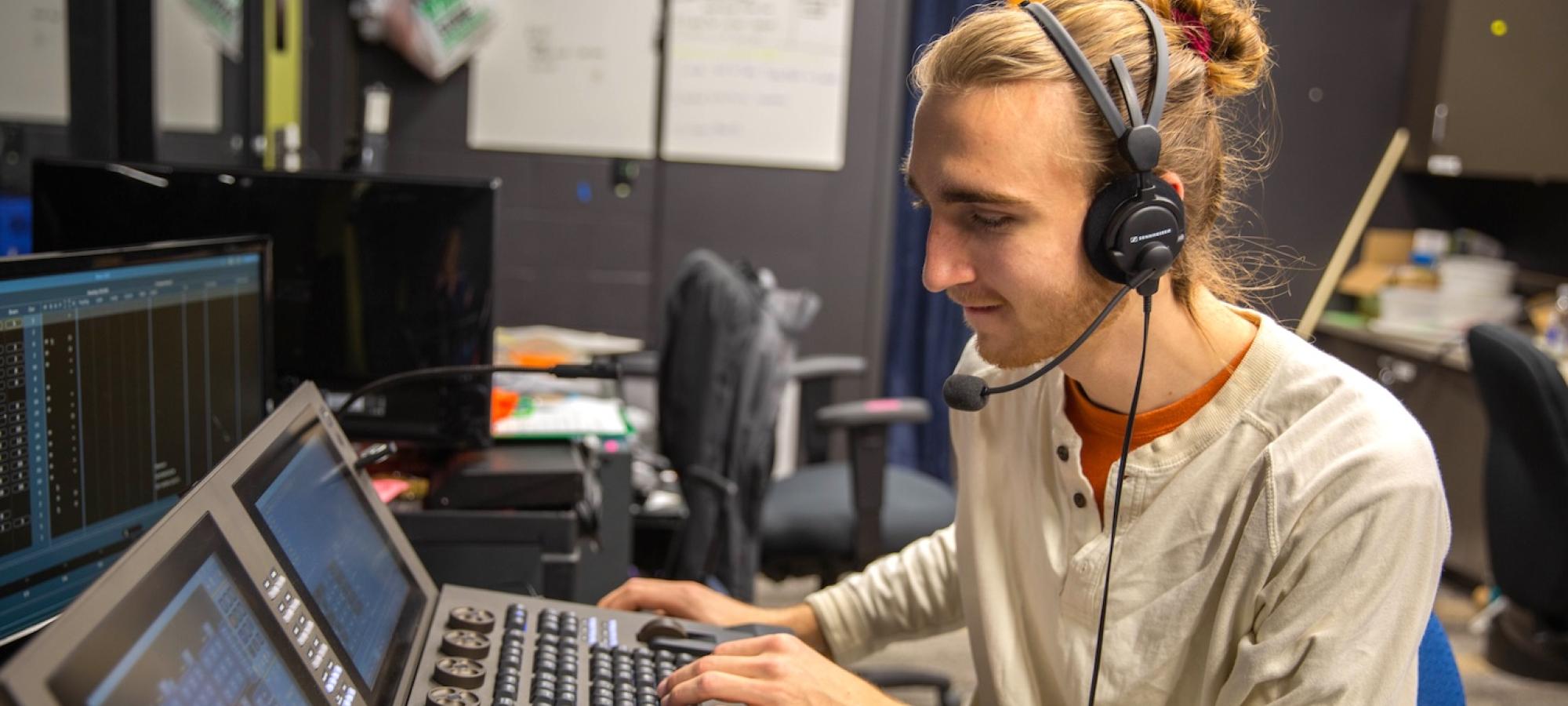 A student works a tech board on a production. 