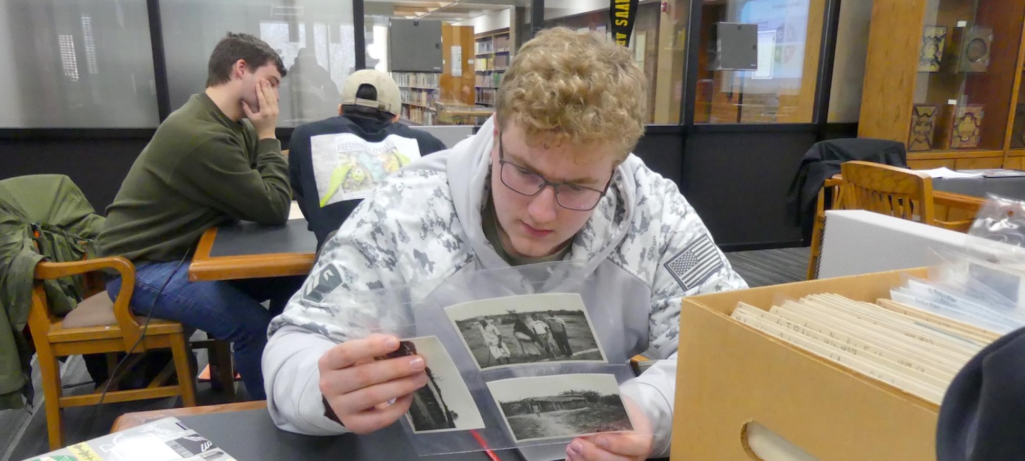 A student looks at archival photos.