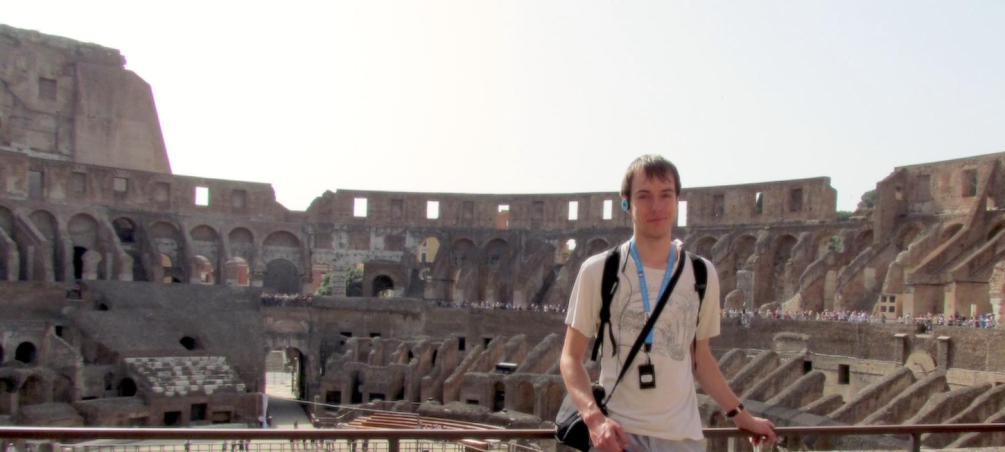 A student stands at the Colosseum. 