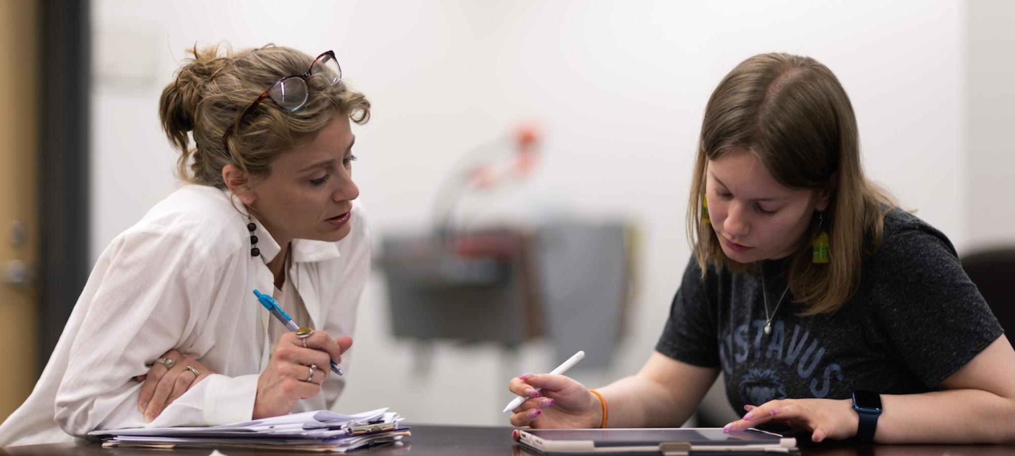 A student and a professor work together on a problem. 