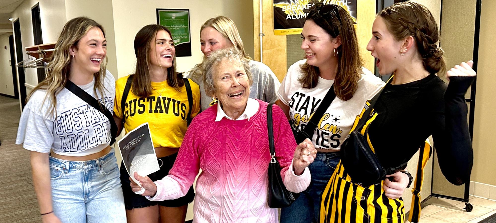 Young and older alumni outside dining room
