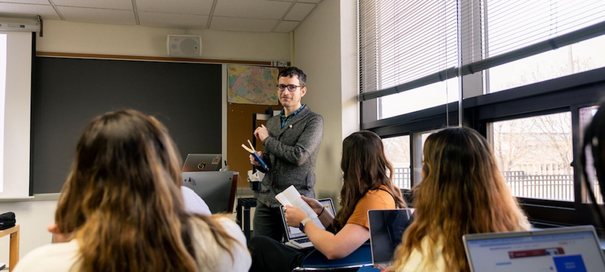 A professor instructs students using a Spanish language document. 