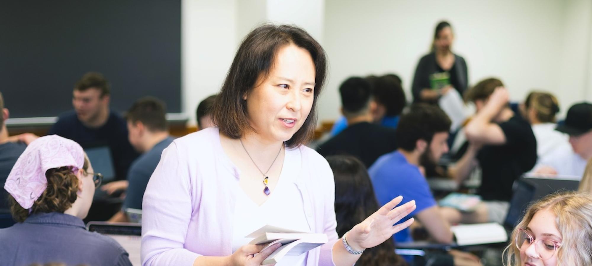 A Gustavus professor teachers a class from a book. 