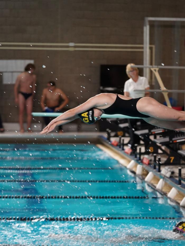 Swimmer diving into pool