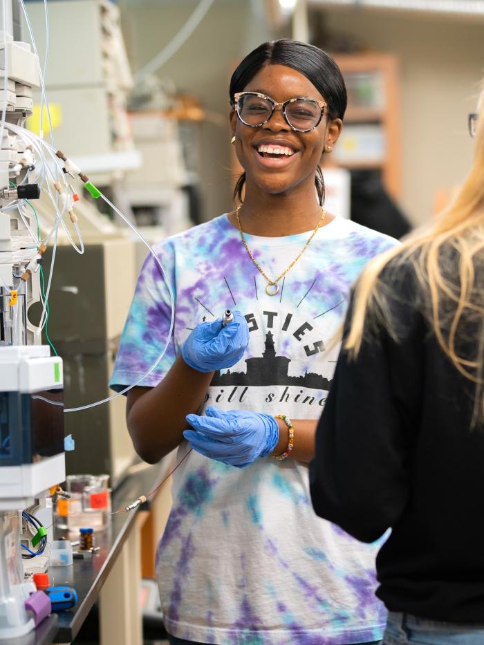 A student in the sciences laughs while doing her work. 