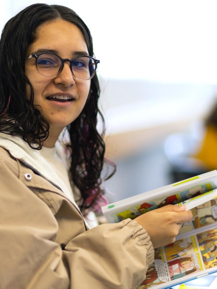 A woman reads a graphic novel. 