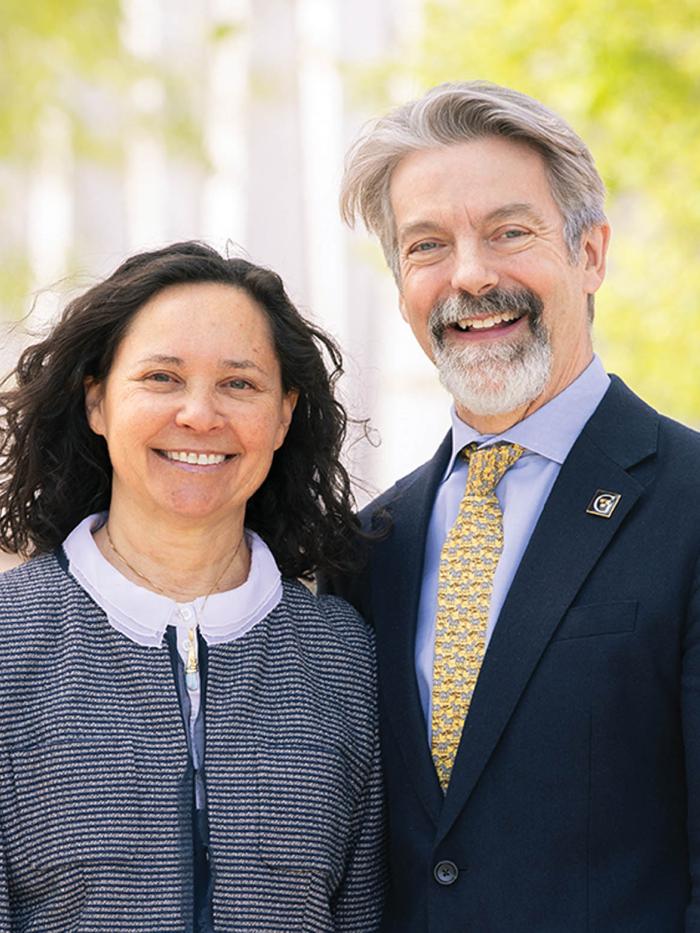 A distinguished couple smiling on the campus of Gustavus Adolphus College