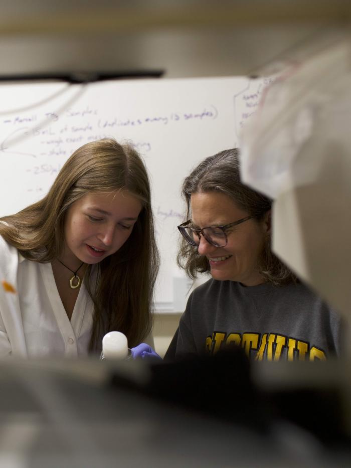A student and a professor work together in a lab. 