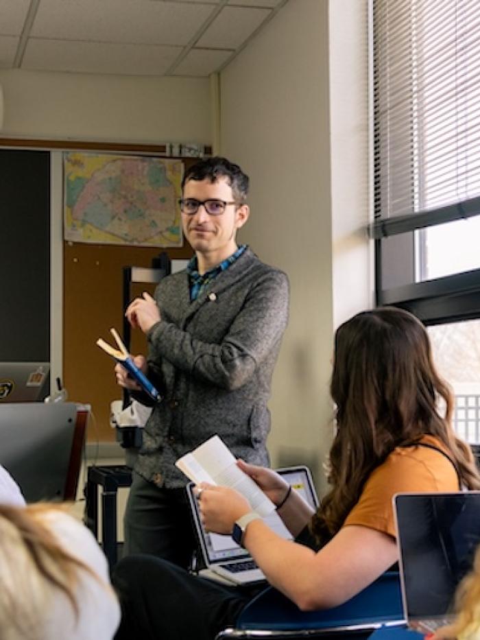 A professor instructs students using a Spanish language document. 