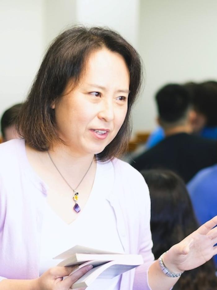 A Gustavus professor teachers a class from a book. 