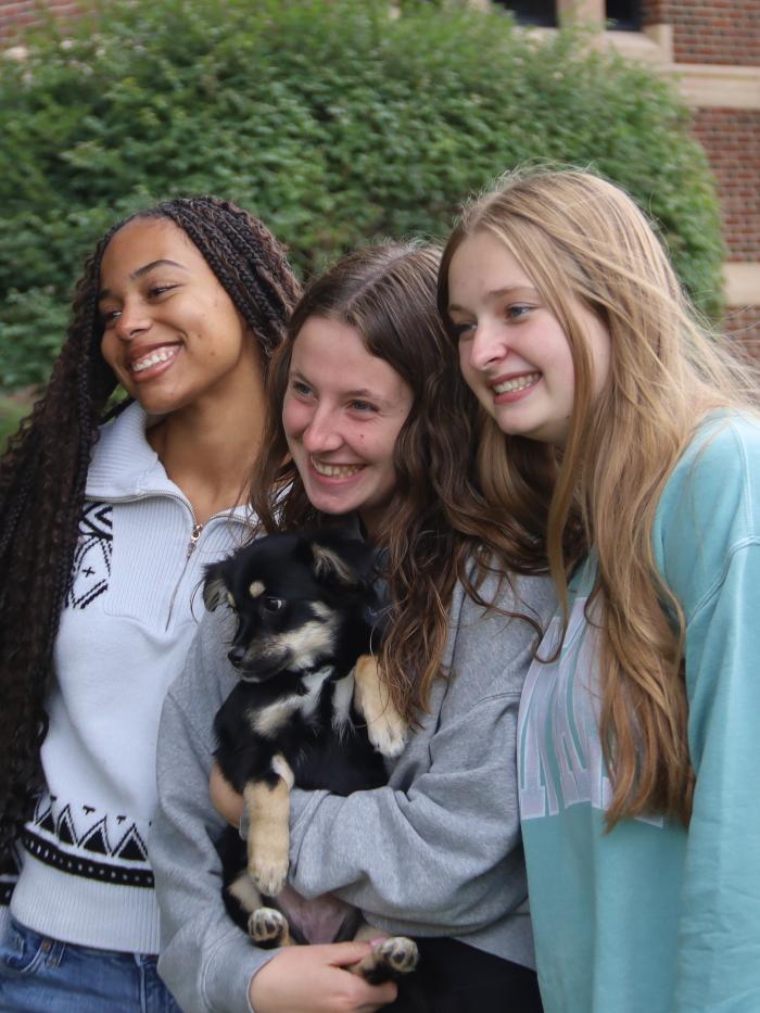 Three girls holding a dog