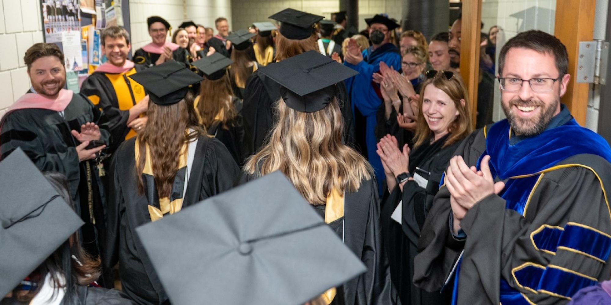 Graduates of Gustavus Adolphus College are applauded by their professors. 